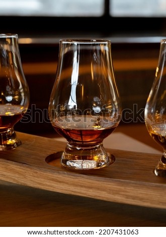 Flight of single malt scotch whisky in glasses served in bar in Edinburgh, UK, tasting of dram of whiskey Royalty-Free Stock Photo #2207431063