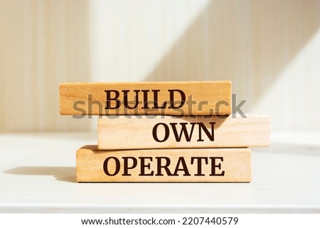 Wooden blocks with words 'Build, Own, Operate'.