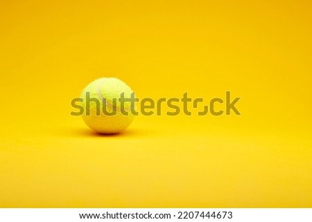 Extreme closeup tennis ball isolated on the bright solid fond plain yellow background. Sport inventory and equipment concept Royalty-Free Stock Photo #2207444673