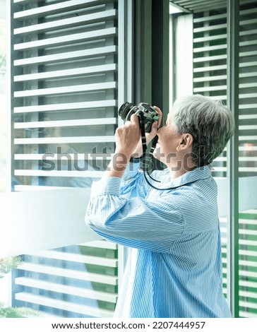 Portrait of happy senior adult elderly asia woman 60s taking pictures with photo camera for travel concept.