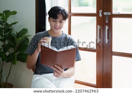 Portrait of an Asian teenager using a digital tablet on the sofa while relaxing at home.