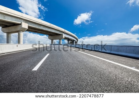 Asphalt highway and bridge under blue sky Royalty-Free Stock Photo #2207478877