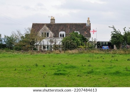 View of an old house on farmland in rural England