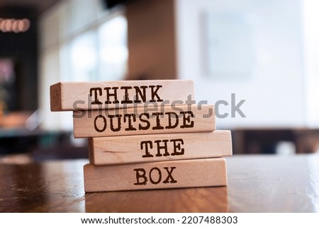 Wooden blocks with words 'Think Outside the Box'.