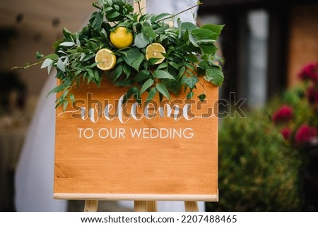 Welcome to our wedding - wedding sign for guests on entrance. Wooden frame or board with welcoming words during marriage ceremony, invitation. Sweet and sour wedding, lemon and greenery decor style.