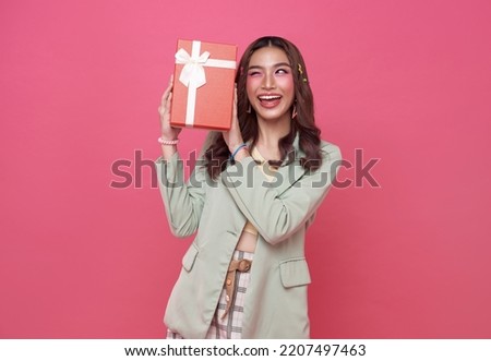 Happy beautiful Asian teen woman smile with red gift box isolated on pink background. Teenage girls in love, Receiving gifts from lovers. Christmas and Valentines Day concept. Royalty-Free Stock Photo #2207497463