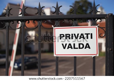 Private property sign on the metal grating of the gate of the fence - a warning about private rights and prohibition of access to the territory