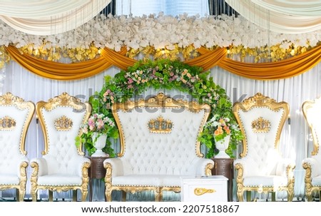 white chair with gold decoration around it.