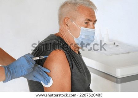 Doctor Vaccinating Senior Man In Clinic. Older People Vaccination. Doctor Giving Monkeypox, Dengue fever or COVID Vaccine Injection to Mature Man. Protection of Elderly Patient. Old Man in Hospital