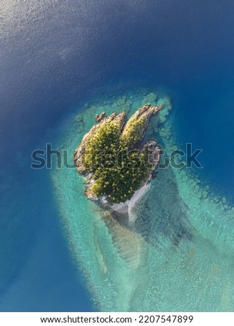 High angle aerial drone view of Arkhurst Island, a small islet next to Hayman Island, a luxury resort hotel in the Whitsunday Islands group near the Great Barrier Reef in Queensland, Australia. Royalty-Free Stock Photo #2207547899