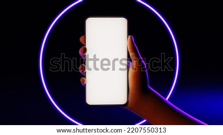 Phone in hand. Silhouette of male hand lit with blue neon lights holding bezel-less smartphone on black neon circle background. Screen is cut with clipping path. 3D Illustration