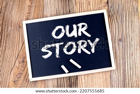 OUR STORY text on chalkboard on the wooden background Royalty-Free Stock Photo #2207555685
