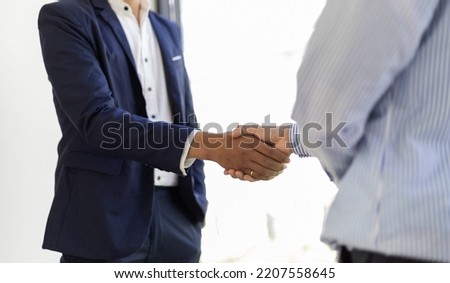 Business people shaking hands during business meeting and partnership agreement contract.