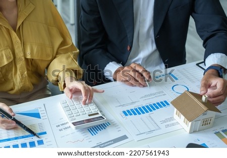 A bank officer in the credit department explains the interest rates on home equity loans to customers in order to assess their investment risks in real estate Royalty-Free Stock Photo #2207561943