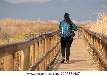 Girl walking on a bridge in a park with natural background
