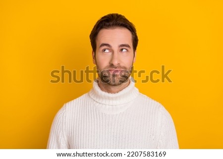 Photo of thoughtful pretty guy dressed white sweater looking empty space isolated yellow color background