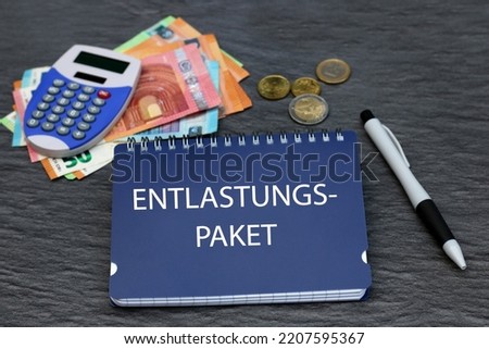 The German word  Entlastungspaket on a notepad with banknotes and a calculator. Entlastungspaket means relief package. Royalty-Free Stock Photo #2207595367
