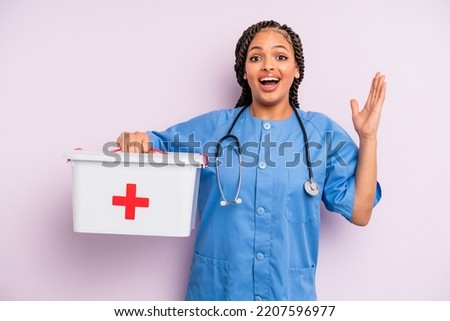 black afro hairstyle woman feeling happy and astonished at something unbelievable. nurse and first aid kit concept