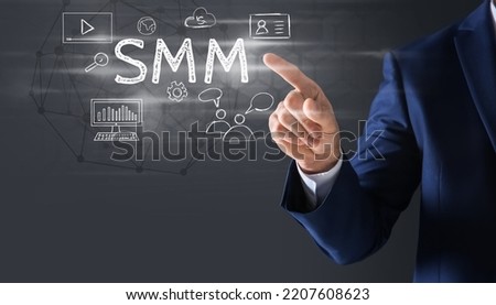 Social media marketing concept. Man touching virtual icon SMM against dark background, closeup