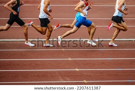 group male athletes run middle distance race Royalty-Free Stock Photo #2207611387