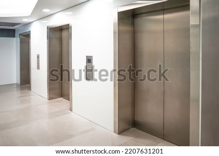 Three elevator doors in office building. Wide angle view of modern elevators with doors. Elevators in the modern lobby house or hotel Royalty-Free Stock Photo #2207631201
