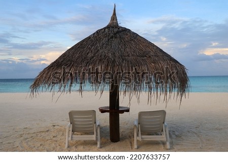 Two Chairs Under Parasol In Tropical Beach  In the Maldives.