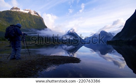 Man taking a picture of the foggy moutains