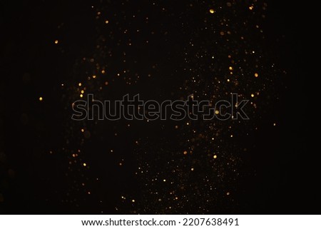 Glowing golden glitter bokeh festive lights abstract dark overlay background