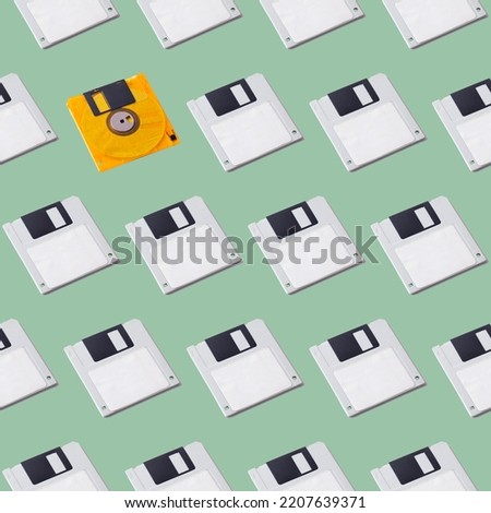 Seamless pattern of floppy disks on a green background, retro devices. Uniqueness, difference from others.