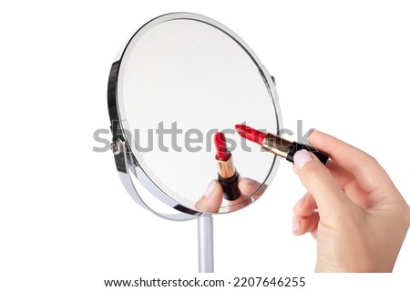 Female hand with red lipstick drawing on mirror. Desktop make up cosmetic mirror isolated. Home metal mirror close up isolated. Facial mirror Royalty-Free Stock Photo #2207646255