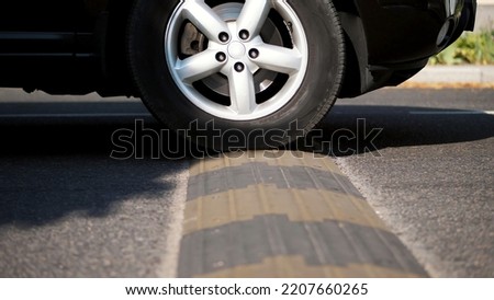 close-up, cars cross special restraint on the road, Traffic safety speed bump on an asphalt road,. High quality photo Royalty-Free Stock Photo #2207660265