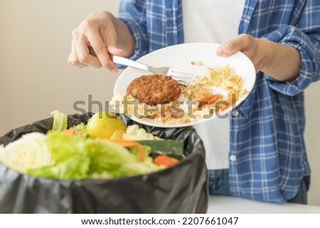 Compost from leftover food, refuse asian young housekeeper woman, girl hand using fork scraping waste from dish, throwing away putting into garbage, trash or bin.
Environmentally responsible, ecology. Royalty-Free Stock Photo #2207661047
