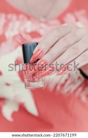 Female hands with long nails and pink orange coral nail polish