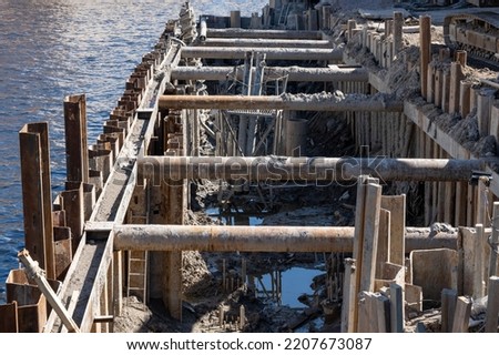 The cofferdam protects the pit from flooding with water. Background picture.