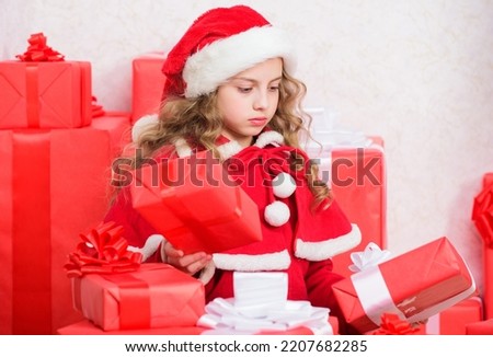 New year holiday tradition. Little santas helper concept. Explore christmas gifts. Unpacking christmas gift. Kid excited about opening christmas present. Girl celebrate christmas. Kid helping santa