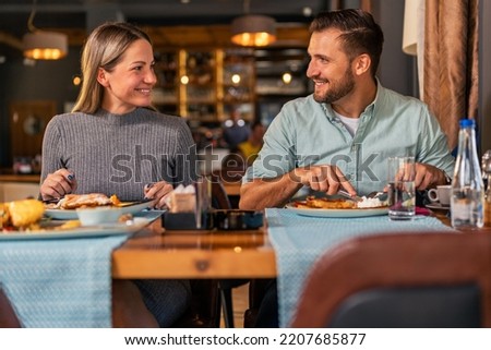 young married couple enjoys a fun lunch time in the restaurant.