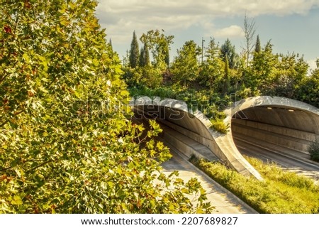 Land bridge over divided highway with trees and vegetation growing on and around it - arched tunnels from above on late summers day Royalty-Free Stock Photo #2207689827
