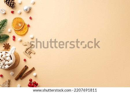 New Year concept. Top view photo of bauble wood deer ornament cup of hot drink scattered marshmallow fir branch cone cinnamon mistletoe dried orange slice on isolated beige background with empty space