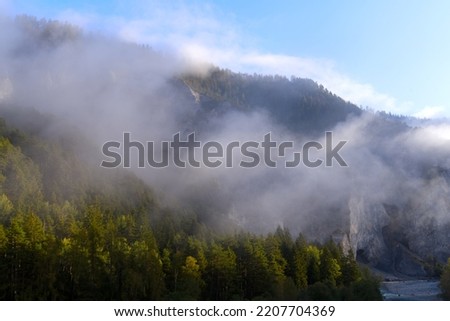 Scenic landscape at Anterior Rhine Valley with cliff, gorge and woodland on a blue foggy autumn morning. Photo taken September 26th, 2022, Versam, Switzerland.