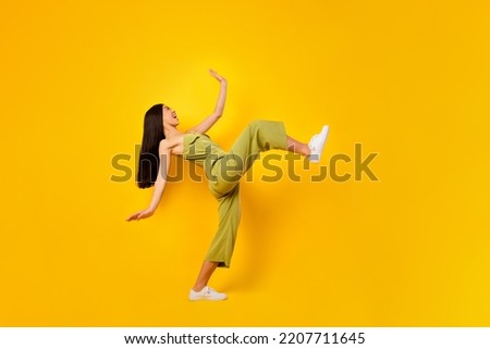 Full length profile photo of positive indonesian person have good mood big step isolated on yellow color background
