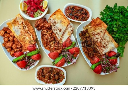 Cig kofte (raw meatball) with lettuce, tomato, pickle and lemon, hot Chee kofta. Turkish local raw food concept.Table scene of assorted take out or delivery foods. Top view of assorted Turkish food. Royalty-Free Stock Photo #2207713093