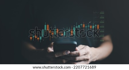 A businessman's or trader's hand is showing a growing virtual hologram stock on a smartphone, indicating an investment in trading. concept of investment management. strategy finance success wealth, Royalty-Free Stock Photo #2207721689