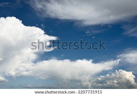 Epic storm cloudscape. White ornamental sunset cumulus clouds. Soft sunlight. Clear blue sky. Natural pattern, texture, background, wallpaper, 3D, graphic resources, design, copy space