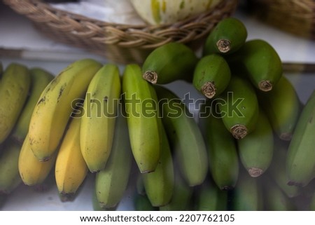 A bunch of bananas on the shop window for sale, Green unripe and yellow ripe to choose from