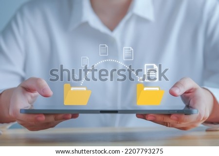 Data transfer, Transfer file of data between folder, Backup data, Exchange of file on folder, Send of document in internet, DMS. Virtual document loading to another folder and hand holding laptop. Royalty-Free Stock Photo #2207793275