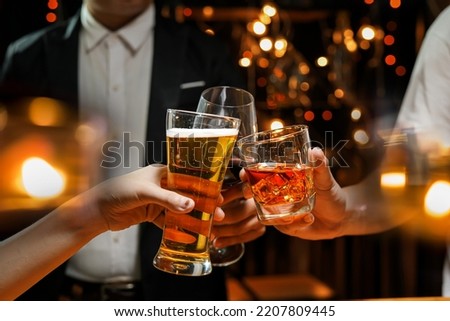 food and drink male friends are happy drinking beer and clinking glasses at a bar or pub. Royalty-Free Stock Photo #2207809445