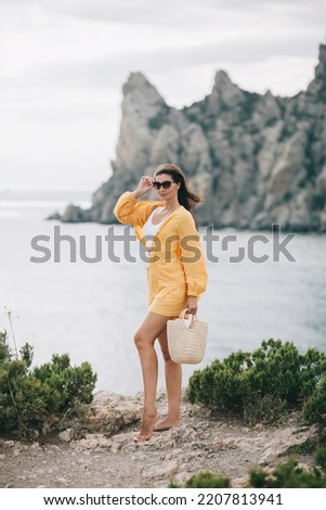 A woman with stunning views of the mountains and the sea. Enjoying nature. Travel lifestyle concept.