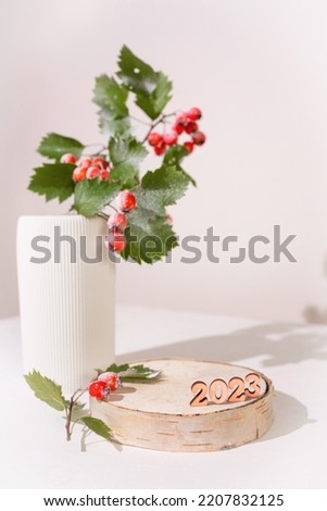 Minimal. Christmas background with a podium for a product presentation . The pedestal is made of natural wood with decorated. Happy New Year and Merry Christmas.