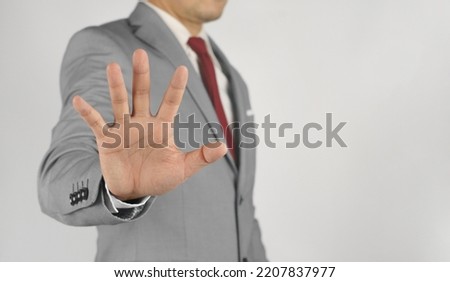Businessman showing stop sign with hands.