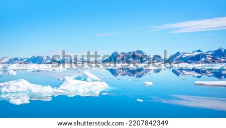View of Greenland glaciers and iceberg from the village of Kulusuk in East Greenland - Kulusuk, Greenland - Melting of a iceberg and pouring water into the sea
